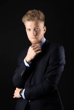 Koyu arka plan üzerinde resmi giysiler şık genç adam