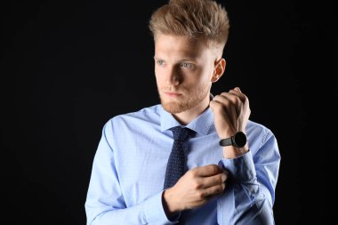 Koyu arka plan üzerinde resmi giysiler şık genç adam