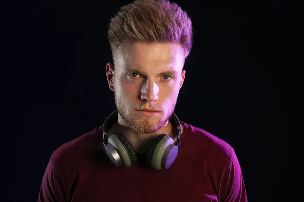 Joven con estilo con auriculares sobre fondo oscuro — Foto de Stock