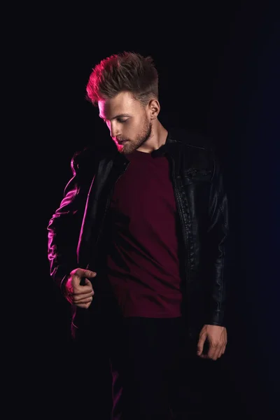 Stylischer junger Mann in Lederjacke auf dunklem Hintergrund — Stockfoto