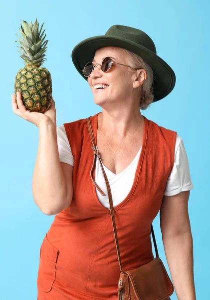 Stílusos érett nő ananász a színes háttér — Stock Fotó