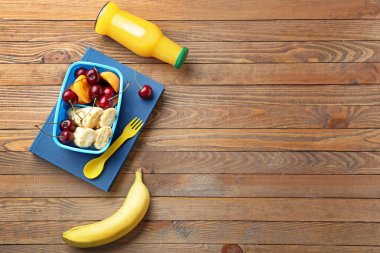 Ahşap masada lezzetli yemek ile Okul öğle yemeği kutusu