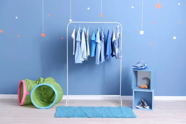 Rack with hanging clothes in interior of dressing room — Stock Photo, Image
