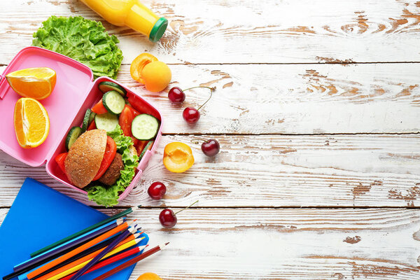 School lunch box with tasty food on wooden table