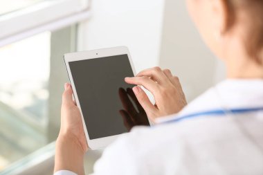 Klinikte modern tablet bilgisayar kullanan kadın doktor, closeup
