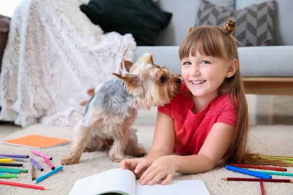 Little girl with cute dog drawing while lying on carpet — Stock Photo, Image