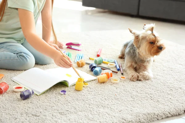 Aranyos kislány kutyafestés ülve a szőnyegen — Stock Fotó