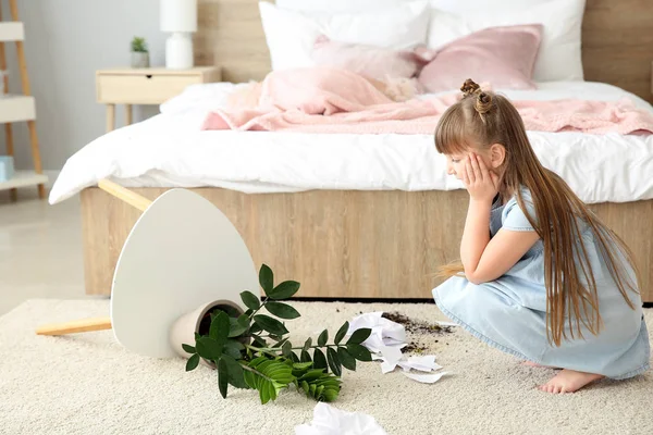 Little girl in room with dropped houseplant and paper pieces on carpet — Stock Photo, Image