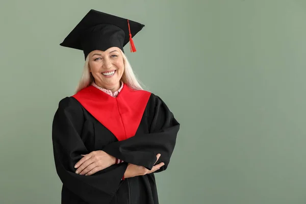 Dospělá žena v bakalářské róbě na barevném pozadí — Stock fotografie