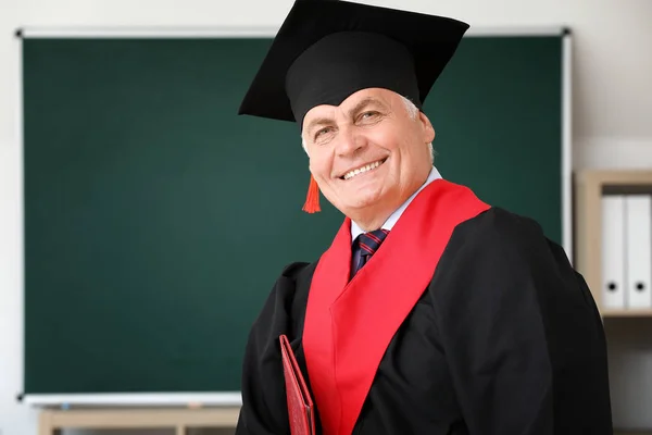 Mature man in bachelor robe in university — Stock Photo, Image