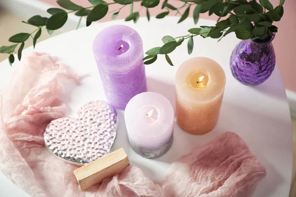 Nádherné hořící svíčky s eukalyptem na stole — Stock fotografie