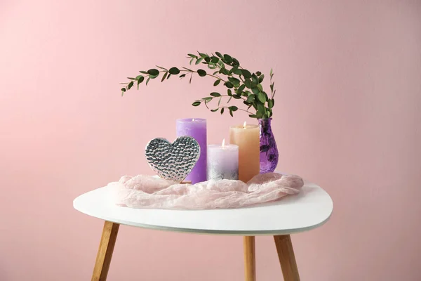 Hermosas velas encendidas con eucalipto sobre la mesa sobre fondo de color — Foto de Stock