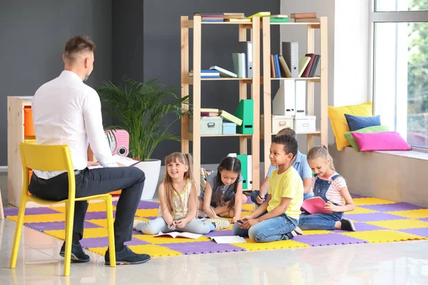 Nette Kinder mit Lehrer in der Grundschule — Stockfoto