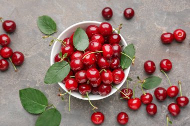 Gri arka planda olgun kiraz ile Bowl