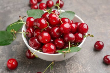 Gri arka planda olgun kiraz ile Bowl