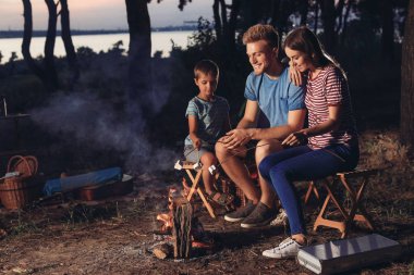 Aile akşam kamp ateşi üzerinde marshmallow kızartma