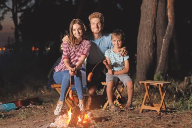 Aile akşam kamp ateşi üzerinde sosis kavurma
