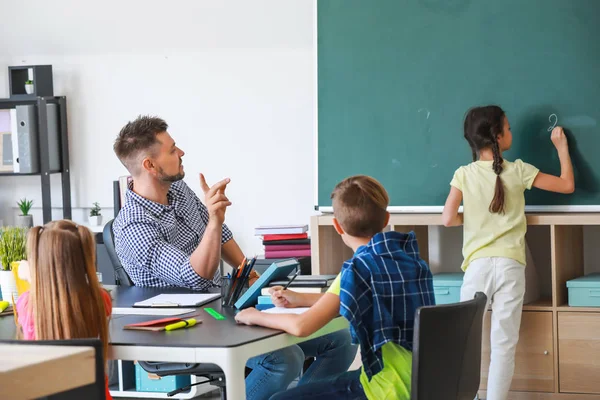 Schattige kinderen met leraar tijdens les in klaslokaal — Stockfoto