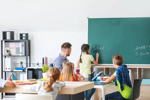 Schattige kinderen met leraar tijdens les in klaslokaal — Stockfoto