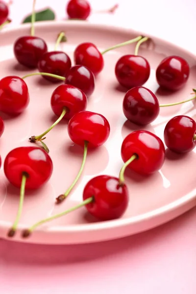 Plate with ripe cherry on color background — Stock Photo, Image