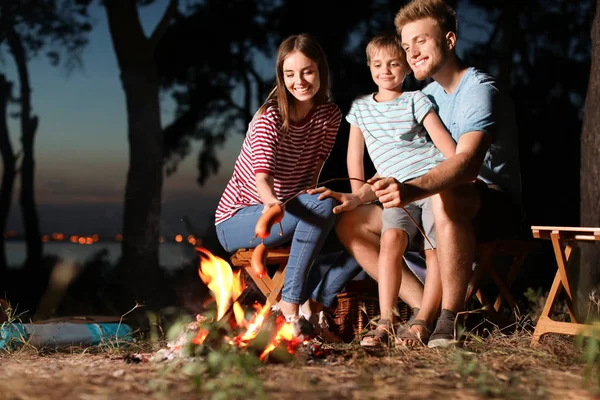 Famiglia arrosto salsicce sul falò in serata — Foto Stock