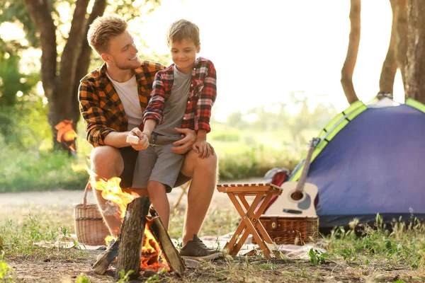 Padre e suo figlio arrostiscono marshmallow in fiamme nella foresta — Foto Stock