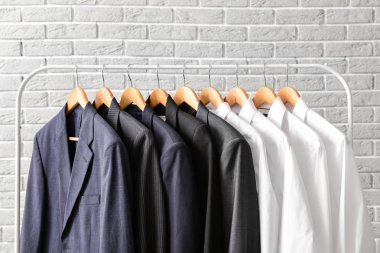 Tuğla duvara karşı asılı giysiler ile Raf