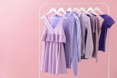 Renkli arka planda asılı giysiler ile Raf