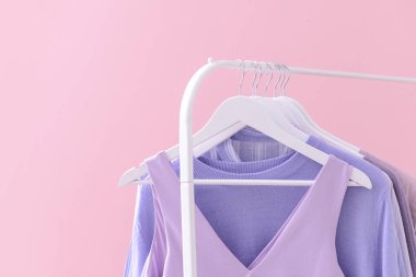 Renkli arka planda asılı giysiler ile Raf