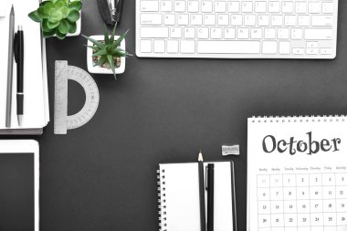 Koyu arka planüzerinde kırtasiye, takvim ve bilgisayar klavyesi ile kompozisyon