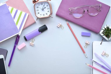 Gri arka plan üzerinde kırtasiye ve çalar saat ile kompozisyon