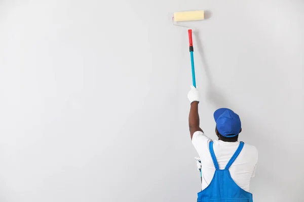 Afro-Amerikalı dekoratör ışık duvarı boyuyor — Stok fotoğraf