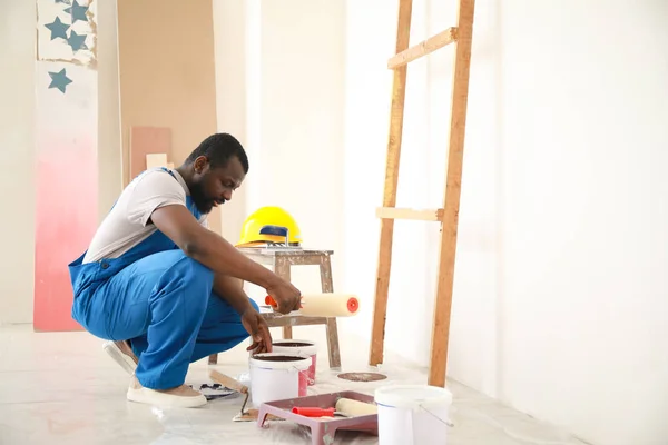 Male African-American decorator doing repair in room — Stock Photo, Image