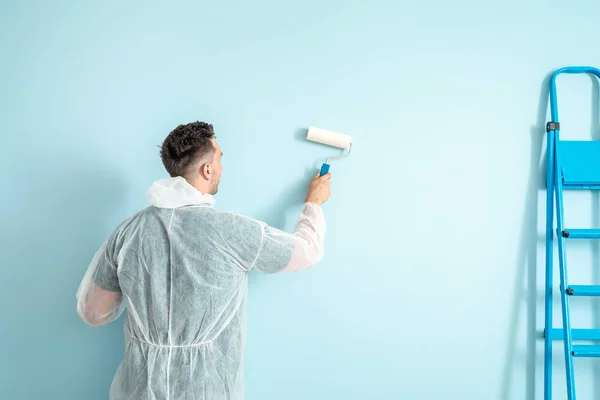 Mannelijke decorateur schilderij muur in de kamer — Stockfoto