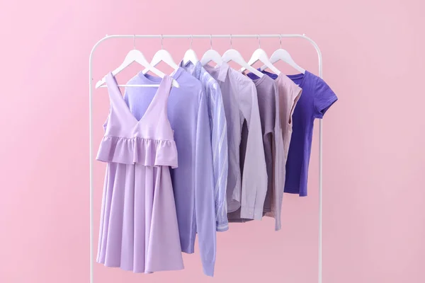 Rack a függő ruhák a színes háttér — Stock Fotó