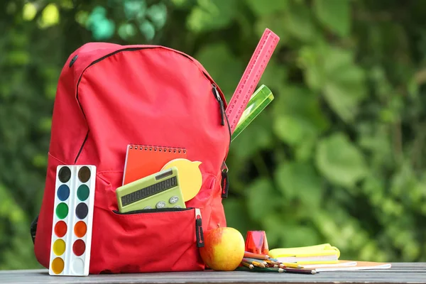 Zaino scuola con cancelleria sul tavolo all'aperto — Foto Stock