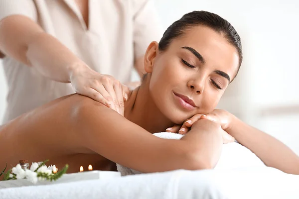 Beautiful young woman receiving massage in spa salon — Stock Photo, Image