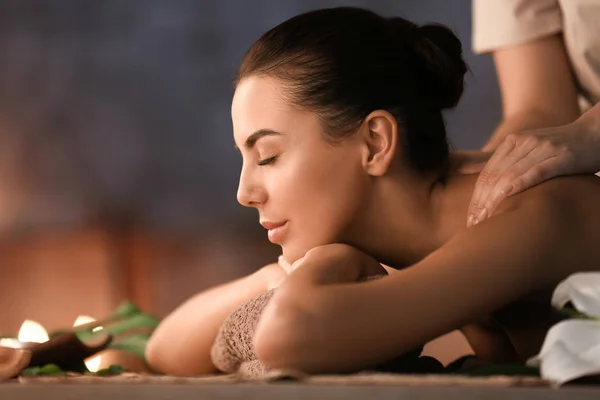 Beautiful young woman receiving massage in spa salon — Stock Photo, Image