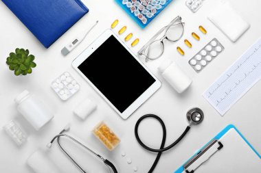 Tablet bilgisayar, haplar, stetoskop ve dizüstü bilgisayar beyaz arka plan üzerinde