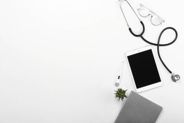 Beyaz arka plan üzerinde stetoskop, tablet bilgisayar, dizüstü bilgisayar ve termometre