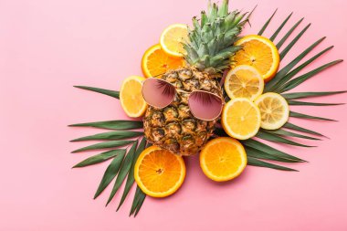 Renkli arka planda tropikal meyveler ile şık güneş gözlüğü