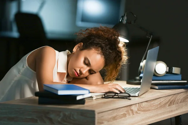 Vermoeide Afro-Amerikaanse student slapen aan tafel in plaats van voorbereiding voor examen in de avond — Stockfoto