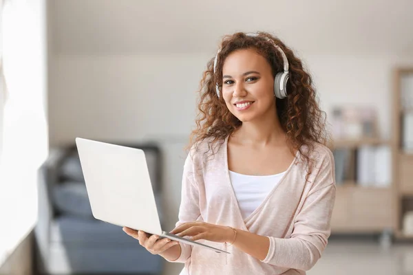 Young African-American student listening to music while preparing for exam — Stock Photo, Image