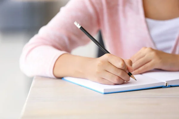Junge Studentin schreibt in Notizbuch, Nahaufnahme — Stockfoto