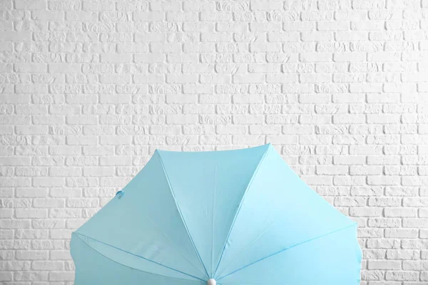 Paraguas elegante cerca de la pared de ladrillo blanco — Foto de Stock