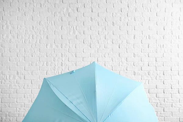 Stylischer Regenschirm in der Nähe weißer Backsteinmauer — Stockfoto