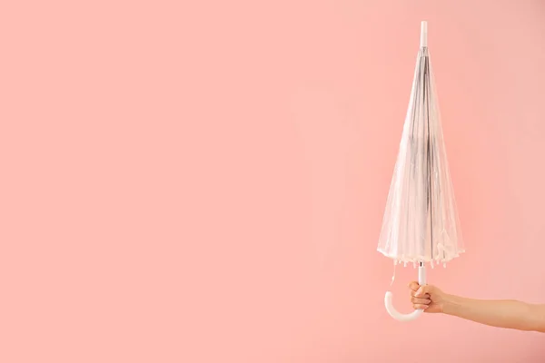 色の背景にスタイリッシュな傘を持つ女性の手 — ストック写真