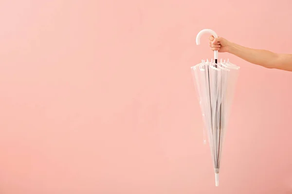 色の背景にスタイリッシュな傘を持つ女性の手 — ストック写真