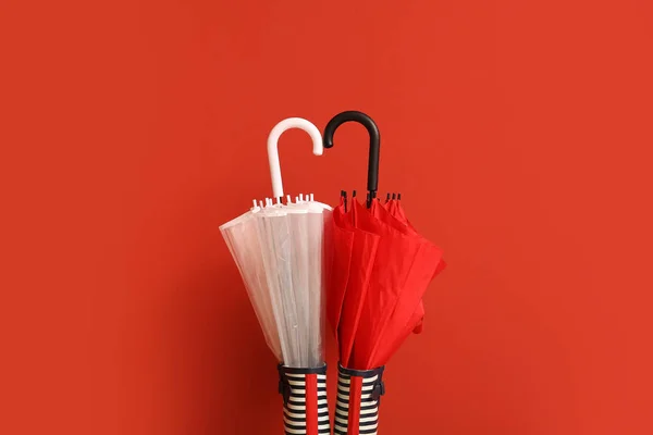 Stylish umbrellas with gumboots on color background — Stock Photo, Image