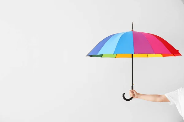 Mão feminina com guarda-chuva elegante no fundo claro — Fotografia de Stock